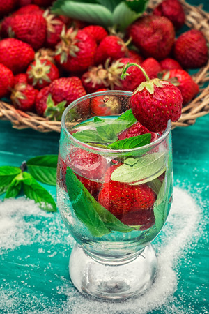 glass with drink of strawberries and mint on the background of the basket full berries.Selective focus.Photo tintedの写真素材