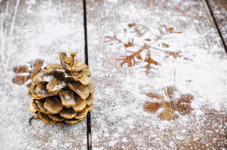 Cedar tower painted in gold color on a snowy wooden backgroundの写真素材