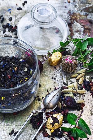 Various dry tea brew on iron background with tea paraphernalia.の写真素材