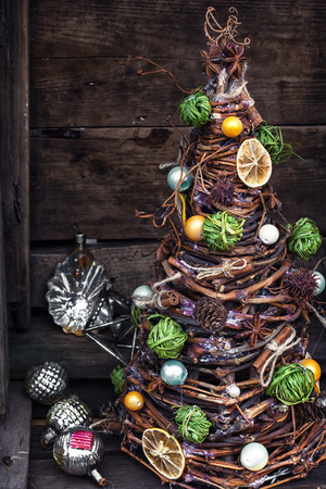 Christmas tree made of wicker,spices and decorations on wooden backgroundの写真素材