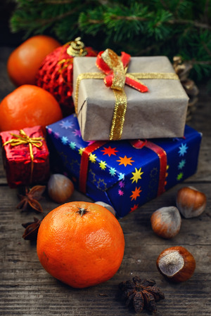 Two small boxes with gifts on the background of tangerine, spruce branch, hazelnutsの写真素材