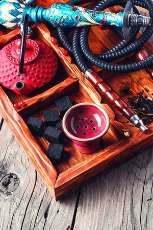 Details of smoking hookah,cast iron red teapot in wooden boxの写真素材