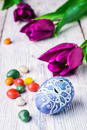 Painted eggs for the Easter holiday and the fresh bud of a tulip