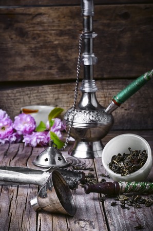 Arab hookah metal and scattered tobacco leafの写真素材