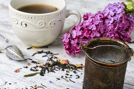 flavored tea, spoon for welding and branch of blossoming lilacの写真素材