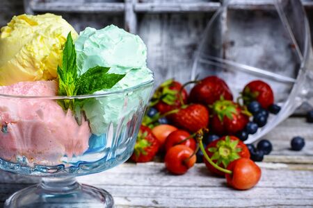 Bowl with fruit ice cream scattered on background of blueberriesの写真素材