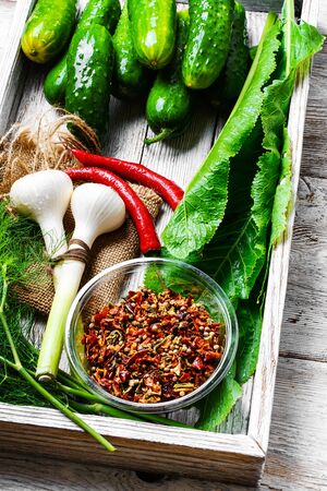 Wooden box with cucumbers and vegetables prepared for seamingの写真素材