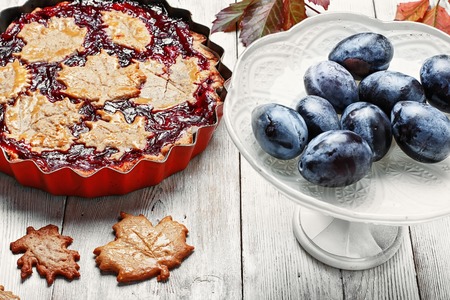 Autumn pie with plum decorated cakes in the form of leafletsの写真素材