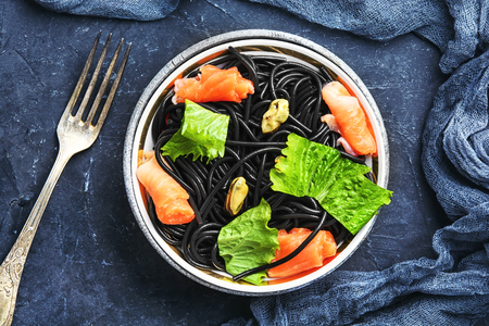 plate of black spaghetti with black mussels and and troutの写真素材