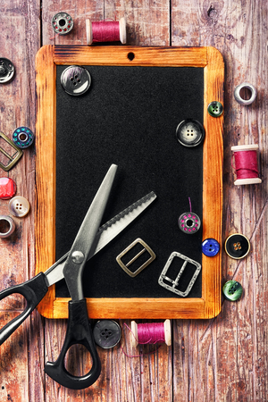 buttons and thread on the chalk board for drawing.の写真素材