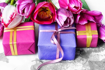 Bouquet of spring purple tulips and a box holiday gift.の写真素材