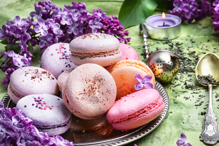 macarons cake and branch of springtime lilac blossomsの写真素材