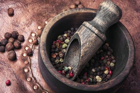 Black and red pepper peas in a wooden mortarの写真素材