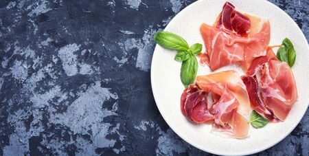 Traditional Spanish jamon on dark stone backgroundの写真素材
