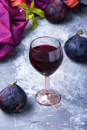 glass with red wine prepared from the autumn fruits of figsの写真素材