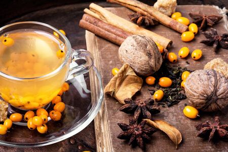 cup with healing tea with sea-buckthorn on wooden retro backgroundの写真素材