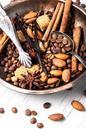 Coffee beans in bowl with anise, cinnamon and almondsの写真素材