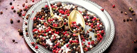Red, white and black pepper on a stylish tray