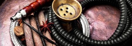 Smoking shisha in east style with tobacco aroma of spices.
