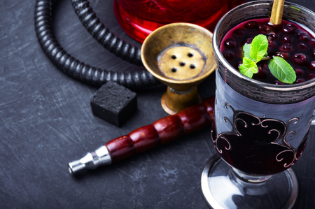 Smoking oriental shisha with alcohol berry cocktail
