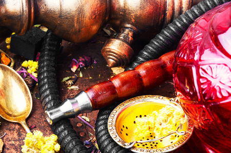 Smoke hookah with herbal floral tea.Shisha concept.Modern hookah