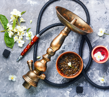 Smoke hookah with jasmine floral scent.Shisha concept.Modern hookah