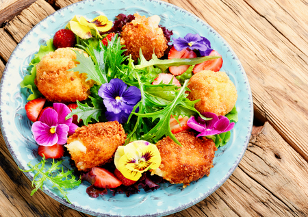 Vitamin summer salad with strawberries, grilled cheese, arugula and flowers.Healthy foodの写真素材