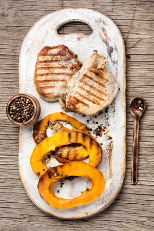 Baked meat with pumpkin on cutting board.Steak with pumpkinの写真素材
