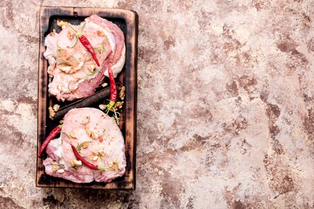 Raw steak on a cutting board with pepper,walnut and spices.の写真素材