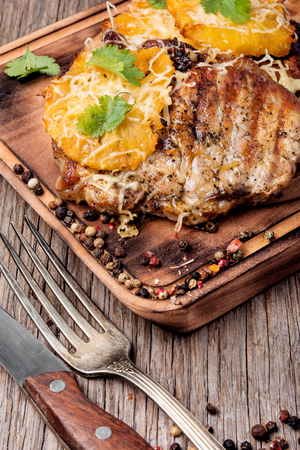 Grilled steak with pineapple on wooden cutting boardの写真素材