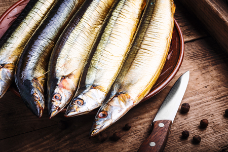 Appetizing smoked fish on kitchen board.の写真素材