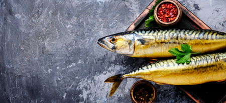 Appetizing smoked fish on kitchen board.Smoked mackerel.Mediterranean foodの写真素材