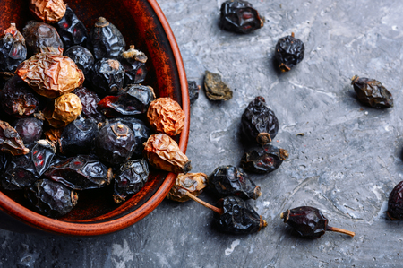 Dried red rose hips in bowl.Medicinal plantsの写真素材