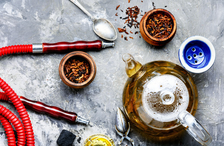 East smoking hookah. Arabian shisha with tea. Hookah and tea.Cooking hookah