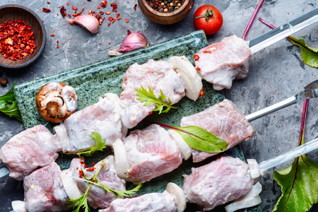 Raw meat shish kebab on a cutting board.の写真素材