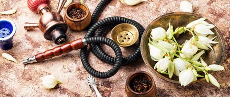 Smoking hookah with floral tobacco flavor.East kalian.Tobacco pipe and smoking tobacco with yucca...