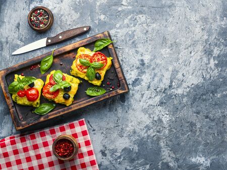Polenta with tomatoes and cheese.Italian cuisine.Pieces corn polentaの写真素材