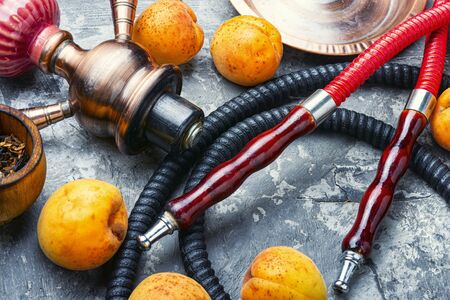 Hookah mouthpiece.Fruit shisha aroma.Tabak with apricot flavor.Kalian smoking with apricotの写真素材