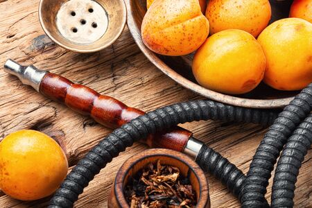 Hookah mouthpiece.Fruit shisha aroma.Tabak with apricot flavor.Kalian smoking with apricotの写真素材