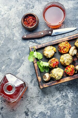 Baked mushrooms stuffed with cheese on cutting board.Italian food.Party snackの写真素材