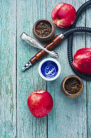 Tobacco shisha with nectarine flavor.Hookah with peach.Mouthpiece of smoking tobacco hookahの写真素材