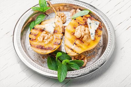 Stuffed pear with walnut and brie cheese.Baked pear.Caramelized pear with nutsの写真素材