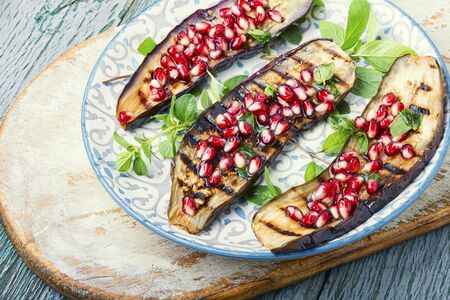Grilled eggplant cooked with pomegranate.Roasted vegetables on plateの写真素材
