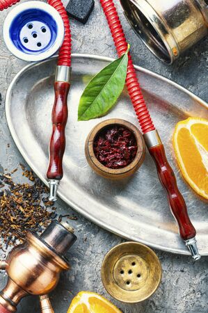 Smoking hookah with the aroma of orange.Details of Oriental hookah.Egyptian kalian