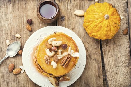 Pumpkin pancakes with maple syrup and nutsの写真素材