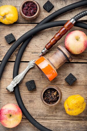Preparation of a smoking hookah.Oriental hookah with a fruit aroma.Hookah on an apple.の写真素材