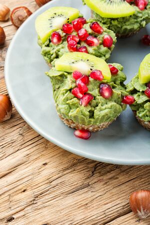 Avocado cupcakes or muffin garnished with kiwi and pomegranate.Cupcakes, close-up.の写真素材