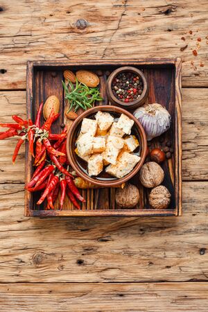 Feta cheese with spice and garlic on old wooden backgroundの写真素材