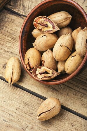 Pecan nuts in bowl on a rustic wooden table