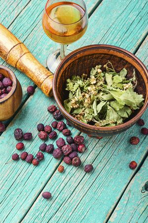 Haw and berry leaves and a glass with healing tincture.Natural herbal medicineの写真素材